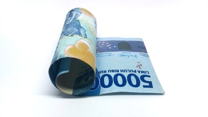 a roll of Indonesian banknotes worth IDR 50,000. Indonesian currency rupiah isolated on white background