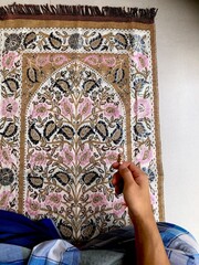 Close up of A portrait of an asian muslim man pray, the pray name is sholat, regards end of sholat. Using blue sarong and brown sajadah