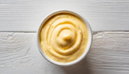 top view on a cup of cheese sauce on white background