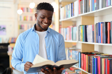 A young man stands confidently in a library, surrounded by shelves of books, embodying the pursuit...