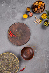 Clay dishes on a gray background with spices and hot chili pepper. View from above