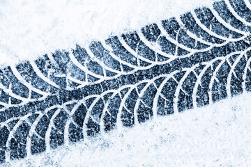 Snow tyre mark. Asphalt covered in snow. Dangerous road conditions. Car imprint on frozen ground....