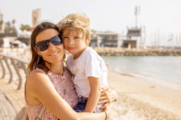 Fototapeta na wymiar Mother and child, family enjoying the seaside views in Tel Aviv on a hot summer day