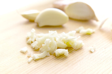 Obraz na płótnie Canvas Minced garlic and garlic cloves on bamboo chopping board. 