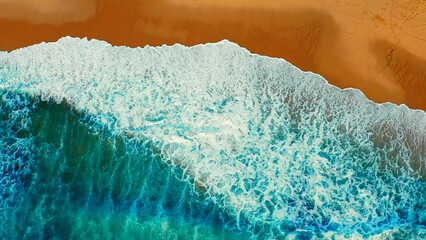 Beautiful ocean beach with yellow sand, aerial view.  Drone view of blue waves and sandy beach. Top view - Beautiful Ericeira beach is famous tourist destination.  Atlantic Ocean, Portugal. © Valua Vitaly