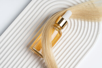 Elegant blonde hair oil product on white background