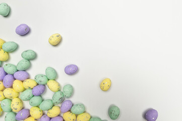 Obraz premium Top view of colourful easter eggs on white background. Creative easter composition, spring, copy space, flat lay.