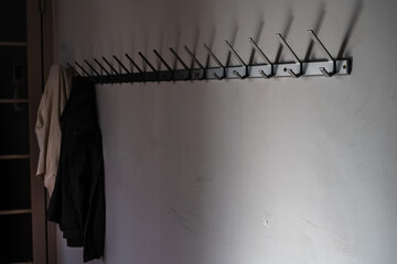Vest accrochée à la fin d'une rangée de crochets de porte-manteau vide.