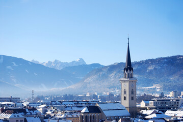 Panorama view of the city Villach in Carinthia, Austria. Big city with beautiful church, ferris wheel, and mountains on the background. Taken in the winter.