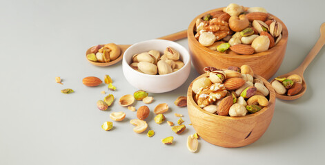 Nuts mixed in wood bowl on green background