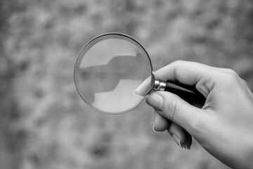 Close-up of hand holding magnifying glass