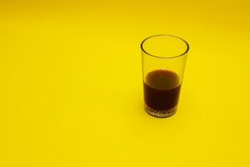 a glass of coffee isolated on yellow background