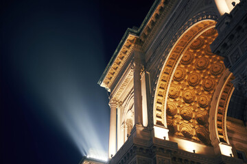 Fototapeta premium Milan at night, showcasing historic buildings bathed in warm light.
