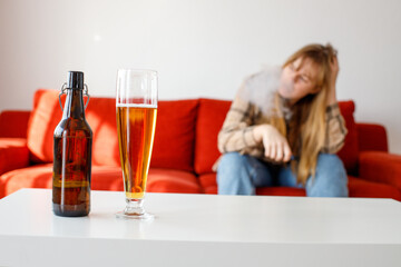 the woman smokes and drinks beer. alcoholism