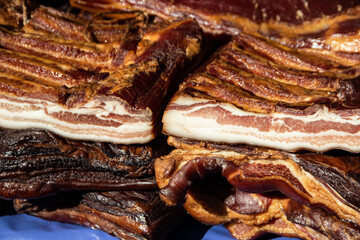 Exposed bacon and dried meat domestic products presented for sale on a farmer's market in Kacarevo...