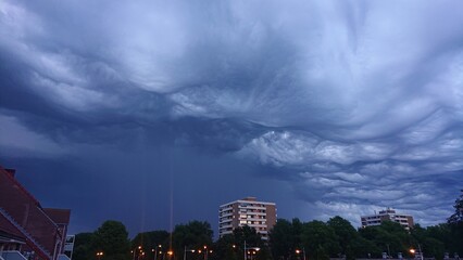 Threatening dark and stormy clouds over city in the Netherlands. Clouds are called Asperitas, formerly known as Undulatus asperatus.
