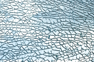 Intricate patterns form in the shattered glass, creating a complex web of cracks. The translucent...