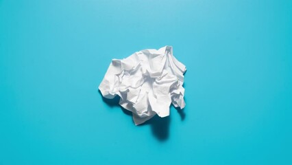 Stop motion animation of crumpled pape on a blue background. High quality 4k footage