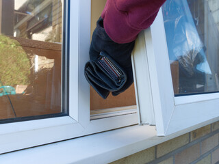 Closeup of the gloved hand of a thief taking a full purse containing credit cards, through an open...