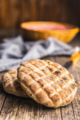 Arabic flat pita bread on wooden table.