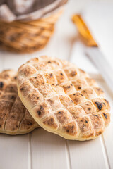 Arabic flat pita bread on white table.