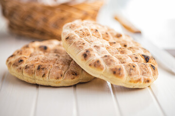 Arabic flat pita bread on white table.