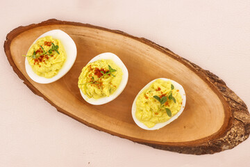 Deviled Eggs with Avocado, Garnish with Paprika Powder and Thyme.