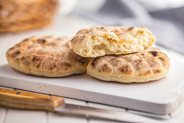 Arabic flat pita bread on white table.