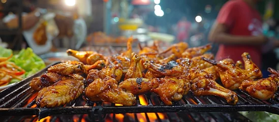 Tuinposter Grilled chicken wings at Jalan Alor street food in Kuala Lumpur © Emin