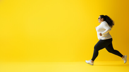 Fototapeta na wymiar A graceful dancer effortlessly glides in her vibrant yellow attire, showcasing her strength and determination as she runs towards the wall, her feet clad in sturdy footwear protecting her knees