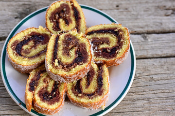 Home made swiss roll cake  with organic eggs and  peach jam covered with sugar on wooden...