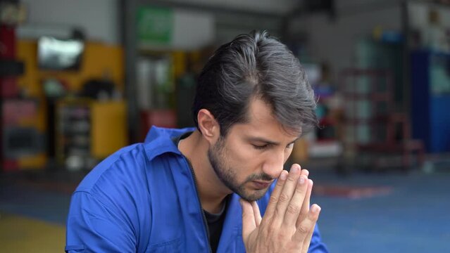 Tired latin auto mechanic bored take a break sitting in garage cars service. Worried hispanic technician repairing auto repair shop . Stress engineer overworked . workers Depressed sad labor burn out