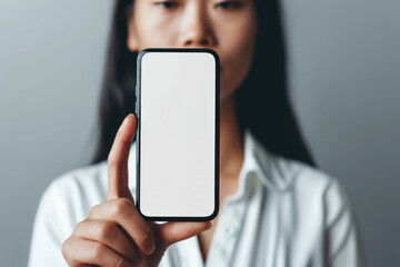 Woman holding up a smart phone with a blank screen - obrazy, fototapety, plakaty