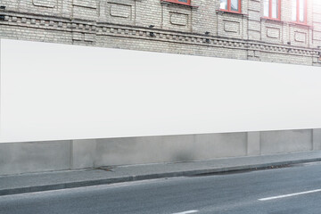 White long blank billboard in front of building on side of empty street with copy space for mock up...