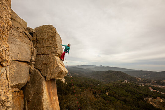 Person climbing in high mountains with yellow jacket rope and helmet in nature, confidence and risk, safety - Powered by Adobe