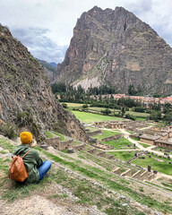 Girl look on the Beautiful view of the ruins of Ollantaytambo Inca archaeological site in southern...