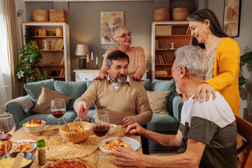 Family sitting at the dinner table and hugging