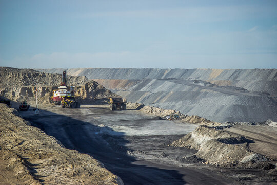 Dump trucks loading up with slag in open cut coal mine