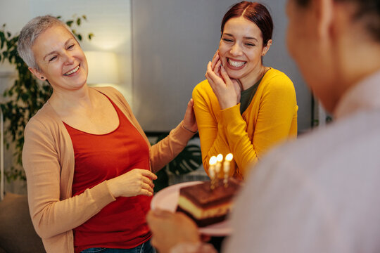 Young woman bringing a birthday cake