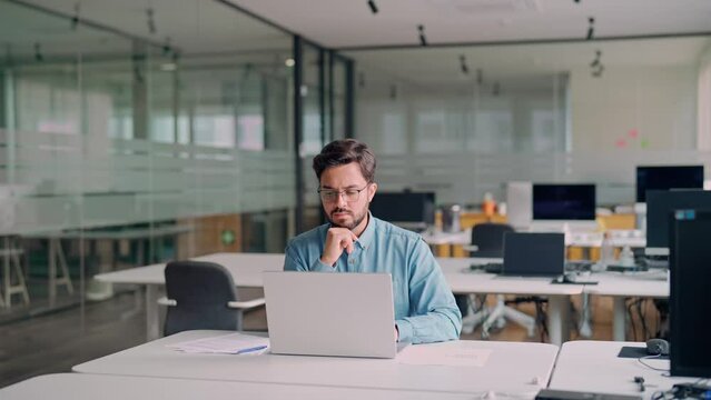 Busy professional business man company employee, young male worker software developer, latin businessman typing on computer technology using laptop searching on web working at office workplace desk.