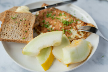 Healthy protein breakfast with egg white omelet, whole wheat toast and honey melon 