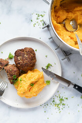 Mashed potatoes with sweet potatoes on a plate with meatballs. Homemade cooked meal