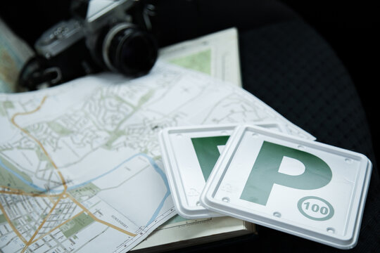 Green p plates, camera and map on car backseat