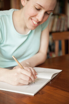 Teen girl doing math work on the table at home