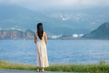 Asian woman wear dress and look at the sea