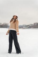 Beautiful young girl in a winter park on a background of snow