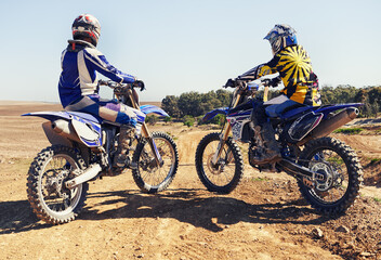 Rear view, sport or racer on motorcycle outdoor on dirt road with relax after driving, challenge or competition. Motocross, motorbike or dirtbike driver and helmet on offroad course or path at rally