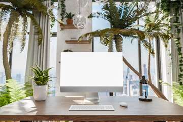 frontal view on modern pc workplace in indoor jungle environment;  white monitor with copy space; urban jungle nature concept; digital home office concept; 3D rendering