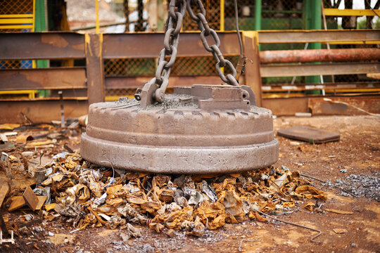 Recycle, metal and rust on magnet in junkyard for sorting, garbage and scrap reuse at landfill site. Steel, iron and industrial electromagnet excavator for urban pollution at waste dump with machine