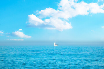 white sailboat on the open sea near the horizon against the background of a cloudy sky. Boat trip....